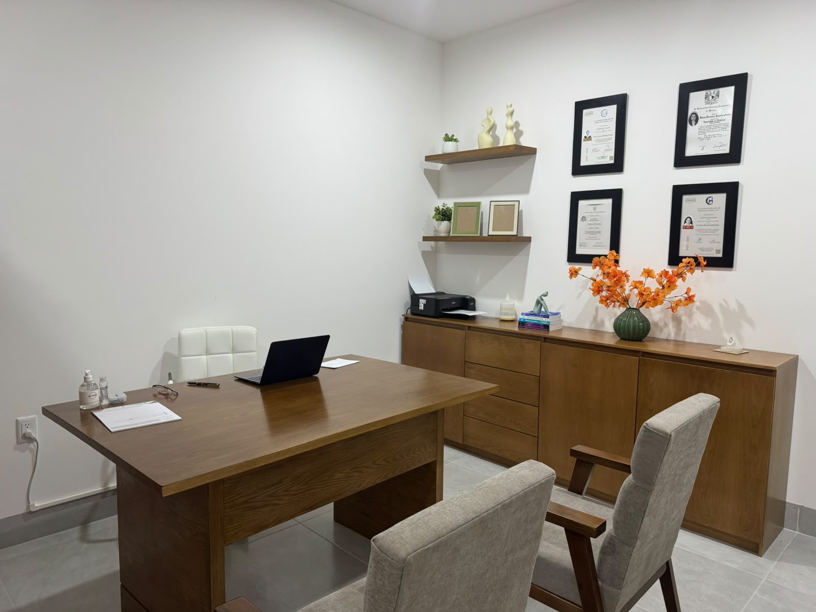 Consultorio de Integra+ con escritorio, credenciales médicas enmarcadas y área de trabajo